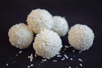Coconut candy with nuts isolated on a black background.