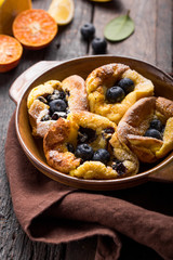 Pannukakku  or Danish pancake with berries topping covered with sugar powder