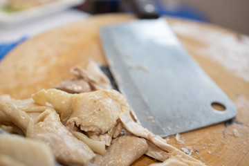 Fototapeta na wymiar Boiled Chicken with a Cleaver on the Wood cutting board