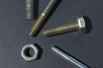 old bolts and nuts on a dark background. Top view.