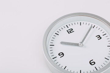 White wall clock with a yellow used hanging on the wall. Minimalist image of a wall clock on a light gray background with copy space