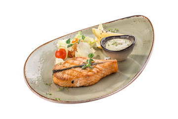 Grilled salmon fillet with lemon and fresh salad on grey plate isolated on white background