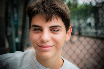 Portrait of smiling teenage boy standing outdoors