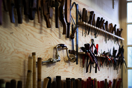 Various hand tools hanging on pegboard in workshop
