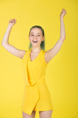 beautiful young woman in a yellow dress on a yellow background