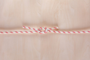 Square or reef ship knot on wooden background