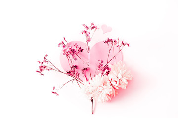 A large pink heart decorated with small pink flowers branch and some chrysanthemum on a pink tint background