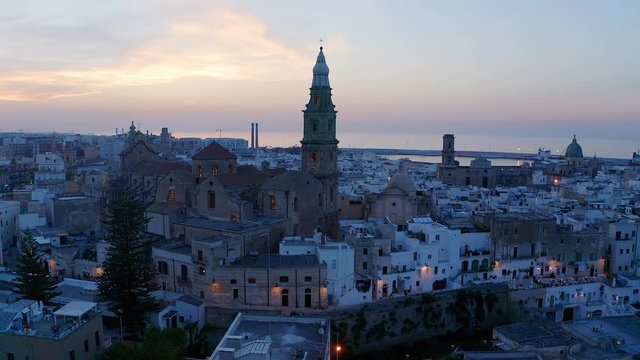 Aerial view, flight at the old town of Monopoli, at dusk, Puglia, Italy,