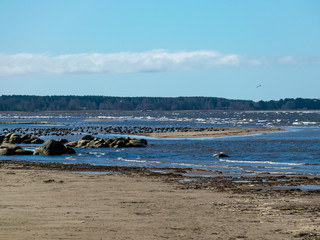 landscape with rocky sea shore, white clouds in the sky