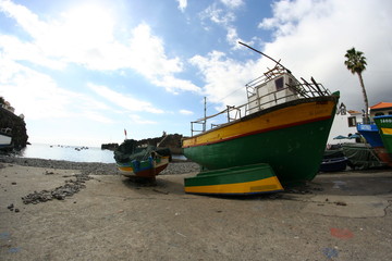 Naklejka na ściany i meble fishing boat in the harbor in camera de lobos at Madeira island