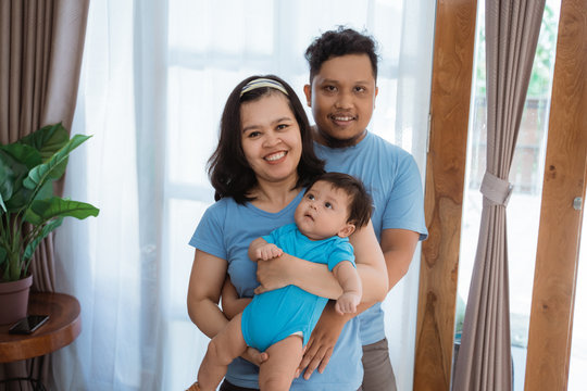 Asian Young Family With Baby Boy Wearing Blue Clothes On Livingroom