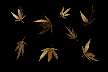 Abstract pattern golden leaves cannabis marijuana fly on black background in minimal branding...