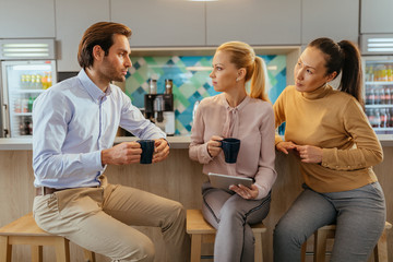 Colleagues drinking coffee during their office break