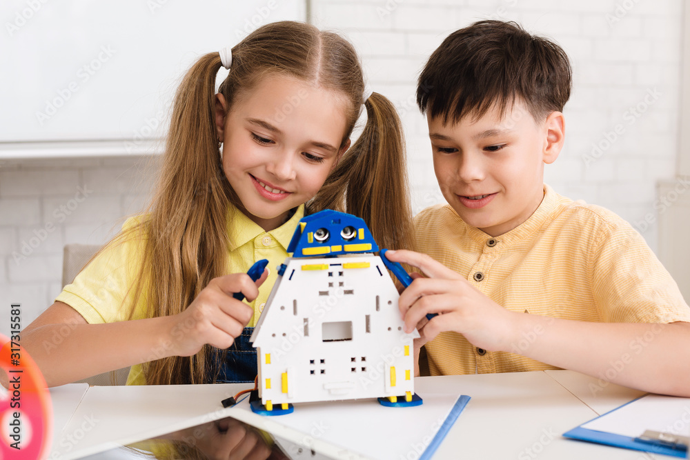 Poster school boy and girl creating modern robot at stem class