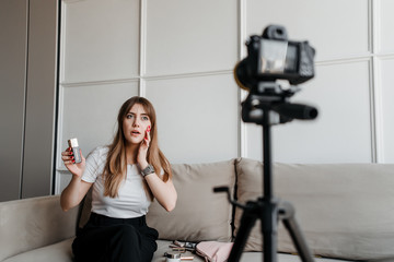 beauty influencer woman recording video makeup tutorial on camera for video blog on the internet at...