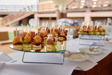 Buffet table with snacks, canape and appetizers at luxury wedding reception outdoors, copy space. Serving food at event. Catering banquet table