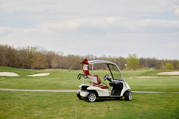 Golf cart on golf course, copy space. Just married sign on red heart on empty golf car outdoors. Wedding concept. Golf club