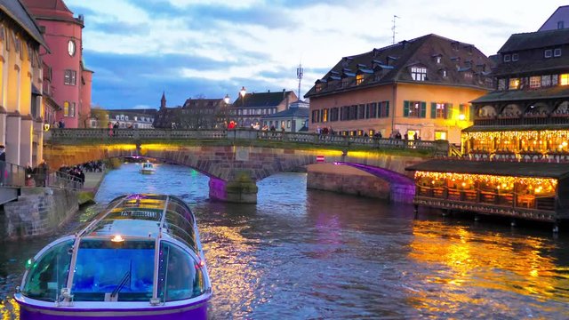 Barco turistico navegando por canal de Estrasburgo al atardecer de navidad