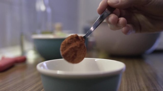 Close shot putting red paprika into a white bowl, preparation in the kitchen, selective focus on hands.