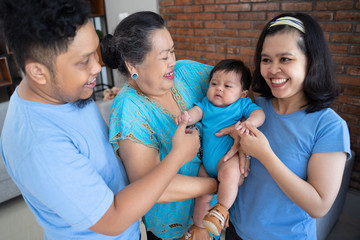Asian families are having fun joking with a cute baby boy enjoying day at home