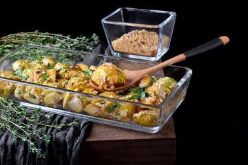 Roasted brussels sprouts topped with nut sprinkle in a glass baking dish