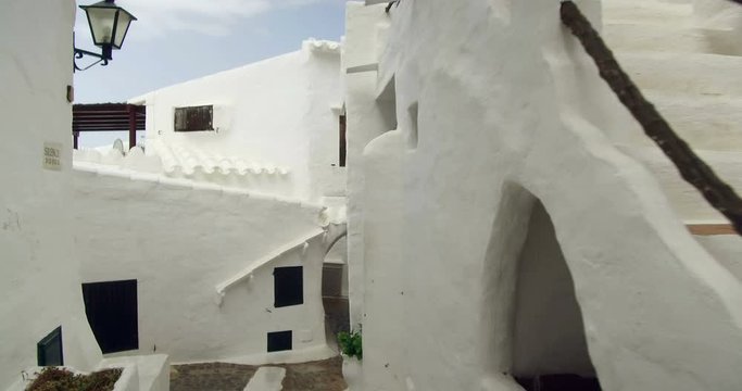 Binibeca old fishing village in Minorca, Balearic Islands, Spain. Walking for very narrow streets of the traditional Mediterranean architecture. Wide angle view with personal perspective camera move. 