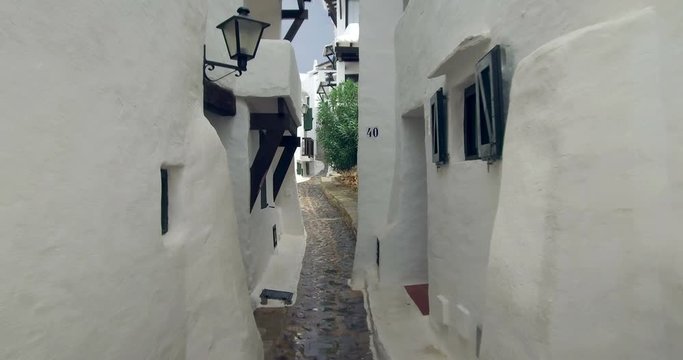 Binibeca old fishing village in Minorca, Balearic Islands, Spain. Walking for very narrow streets of the traditional Mediterranean architecture. Wide angle view with personal perspective camera move. 