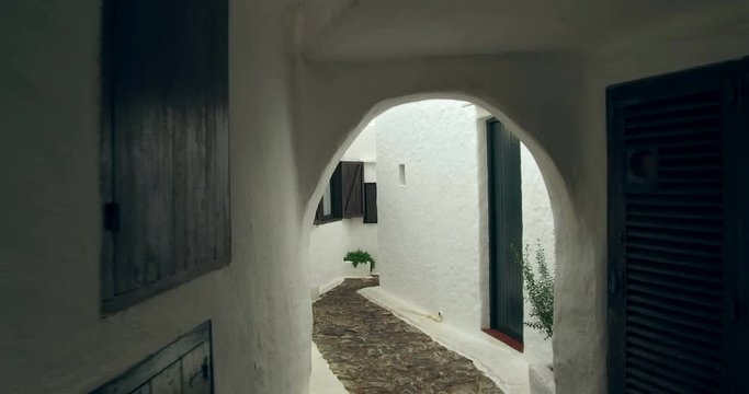 Binibeca old fishing village in Minorca, Balearic Islands, Spain. Walking for very narrow streets of the traditional Mediterranean architecture. Wide angle view with personal perspective camera move. 