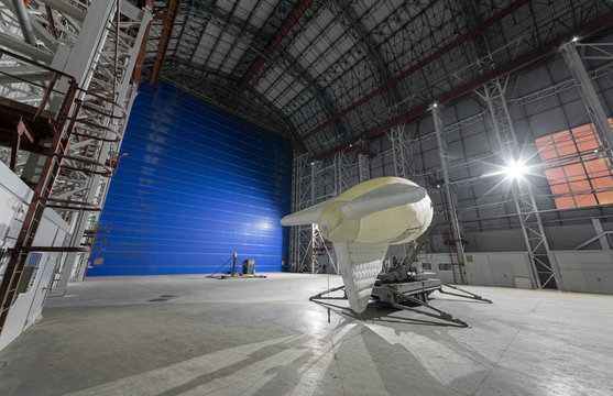 Aerostat on a mobile mooring platform inside an giant airship hangar with huge blue gates