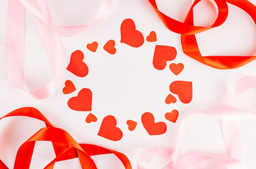 red hearts on white background with pink and red ribbons. frame. valentine day concept 