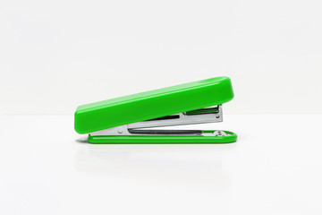 Green stapler isolated on a white background