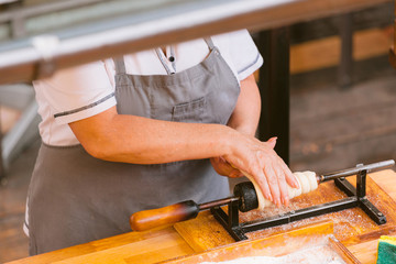 Woman preparing Traditional national Czech Trdelnik bakery.