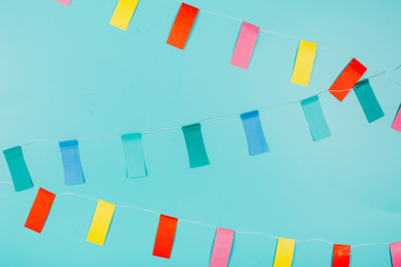 Multicolored paper flags on blue background. Festive concept.