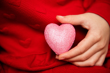 White Caucasian Female hand close up giving, holding glitter sparkle heart. Valentine day. February 14. Love concept   