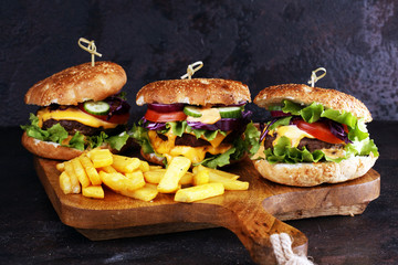 Tasty fresh meat burgers with salad and cheese and french fries. Homemade angus burger.