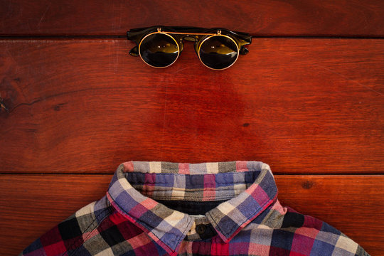shirt and glasses on wooden background in studio
