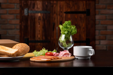 Ingredients for sandwich: lettuce, bacon, tomatoes, bun.