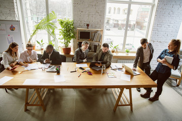 Being best. Group of young business professionals having a meeting. Diverse group of coworkers discuss new decisions, plans, results, strategy. Creativity, workplace, business, finance, teamwork.