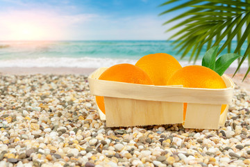 Oranges in a basket by the warm sea.