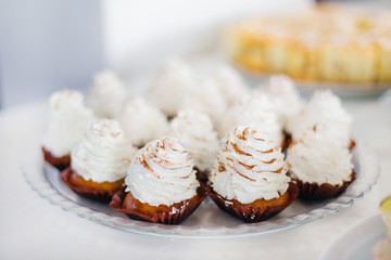 cupcakes covered with white cream on a plate. wedding banquet.