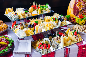 large assortment of cheese decorated with grapes and strawberrie