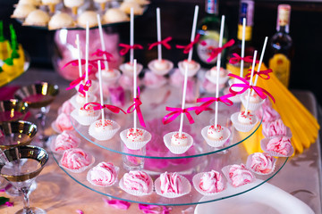 Fototapeta na wymiar transparent stand with pink cake pops and meringue. desserts and
