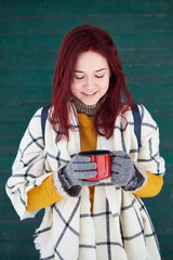 beautiful girl is drinking a hot drink in the winter in nature, tea, coffee