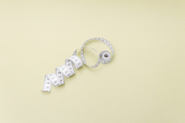 Measuring tape on yellow background. Free copy space.