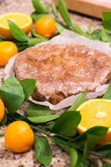 Orange cake surrounded by oranges and leaves