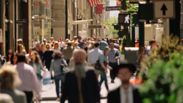 Anonymous crowd walking in New York City. Busy Manhattan street, full of tourist and business people. 