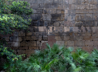 Fragment of ancient stone wall made of different form and size blocks with black stains on it....