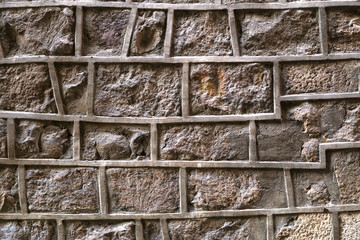 Old stone wall with irregularly shaped joints. Unusual brick wall background.