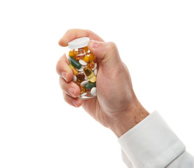 Man hand opening glass bottle full of pills, tablets, vitamins, drugs, capsules isolated on white background. White shirt, business style. Health care concept. Pharmaceutical industry. Pharmacy.