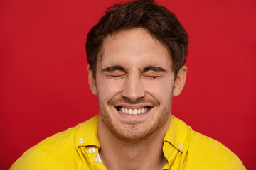 Happiness, ethnicity, fun and people concept. Smiling handsome man in yellow shirt with closed...